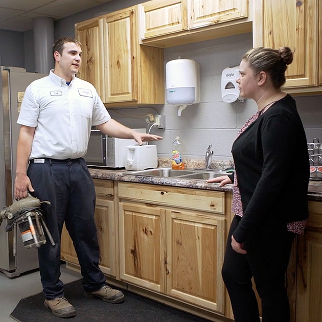 One of our helpful plumbers talks to a Cheektowaga homeowner about their new in-sink garbage disposal.