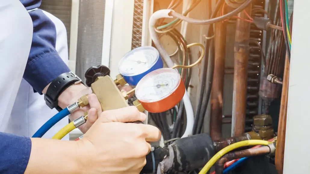 A Reimer technician checks the refrigerant levels of an air conditioner at a local home.