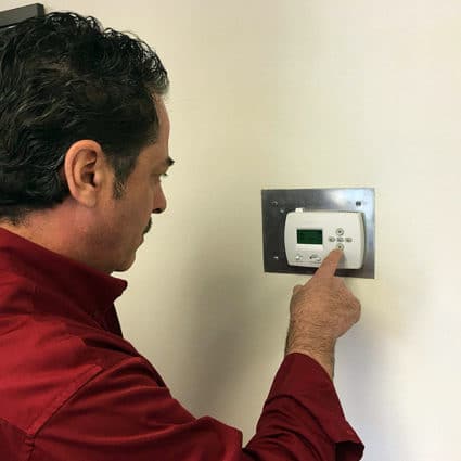 One of our techs checks that the thermostat is working properly as part of our heater tune-up in Tonawanda.