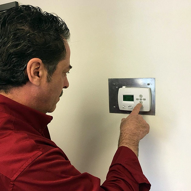 One of our techs checks that the thermostat is working properly as part of our heater tune-up in Tonawanda.