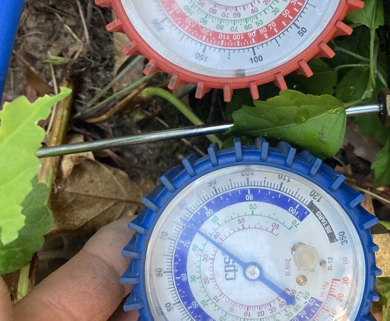 During an AC repair visit, our technician diagnoses the problem by checking the unit's refrigerant levels.