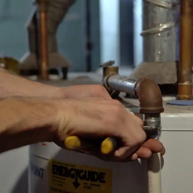 Our plumber tightens the pipe connecting this home's plumbing to its water heater.