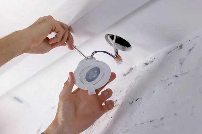 electrician installing a light
